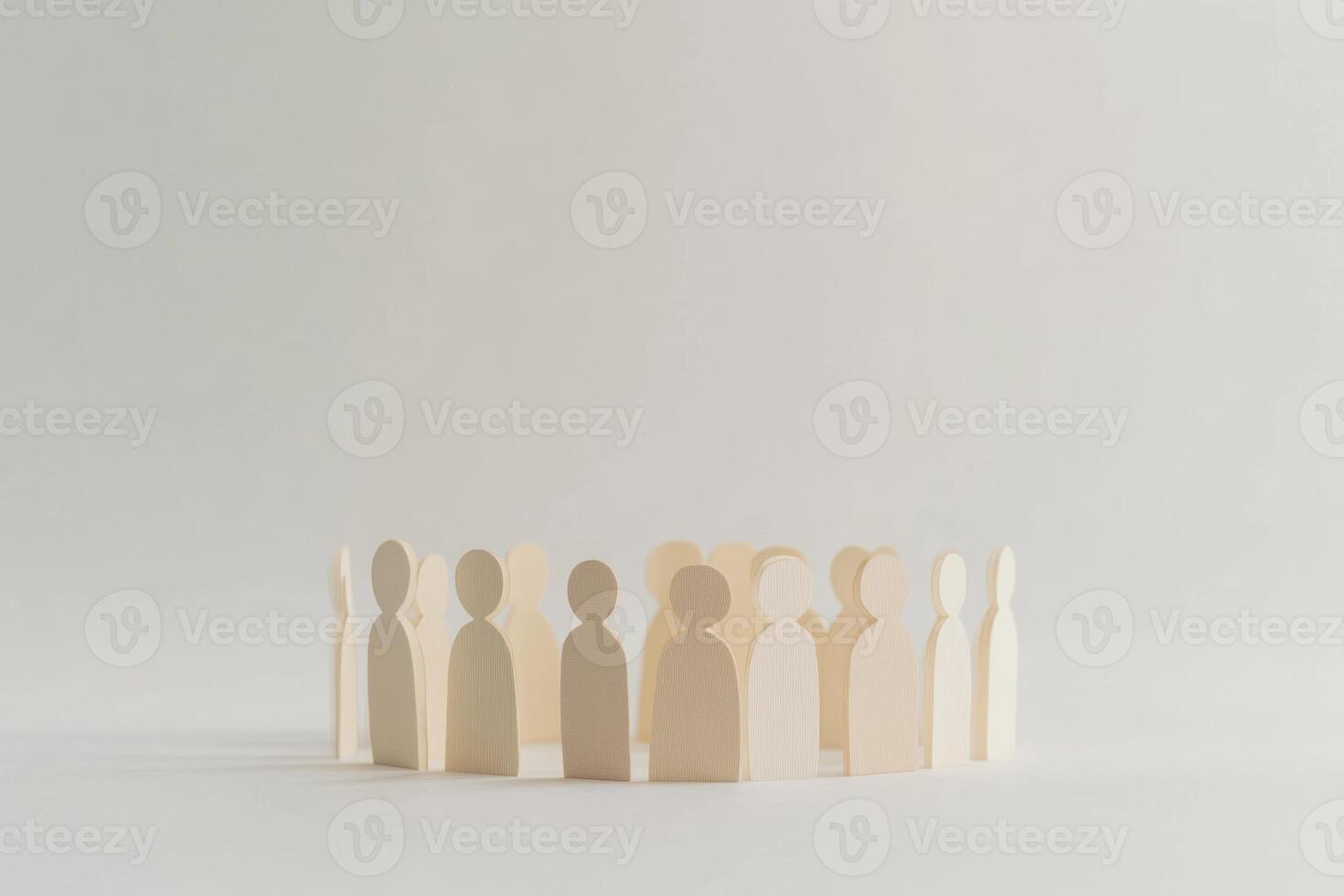 Wooden figures representing people in a circular arrangement on a light background photo