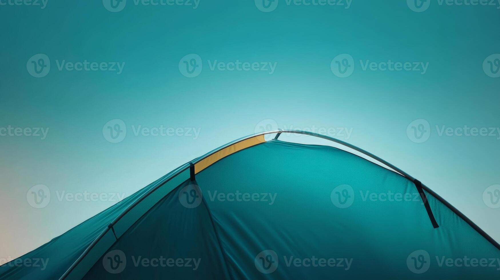 Camping tent silhouetted against a vibrant sky at twilight in a serene outdoor setting photo