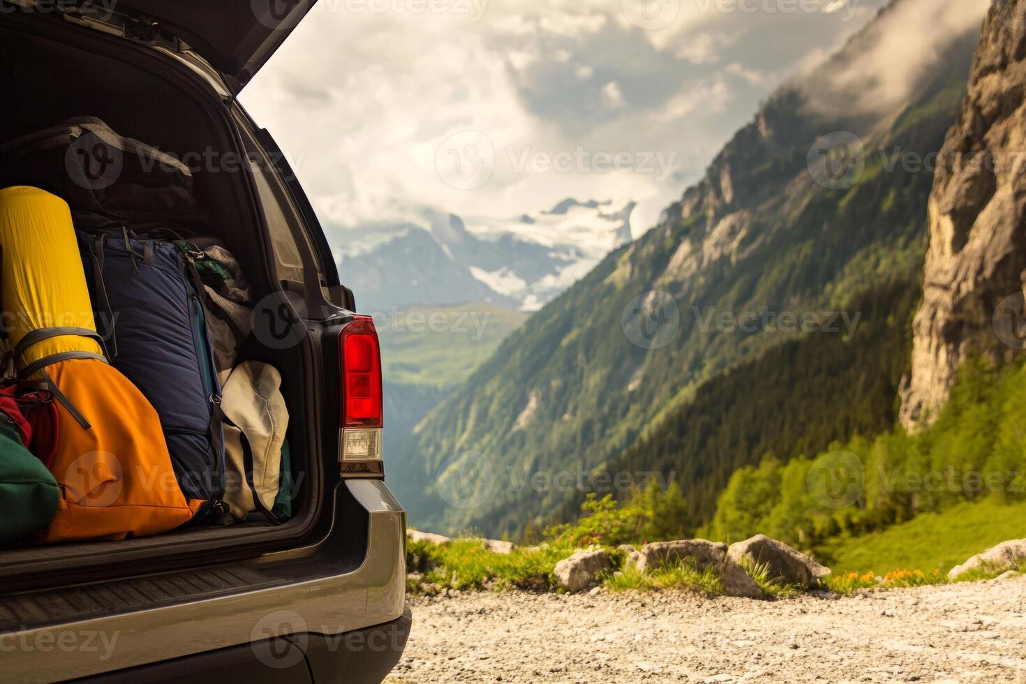 Scenic mountain view with open vehicle trunk displaying camping gear in summer photo