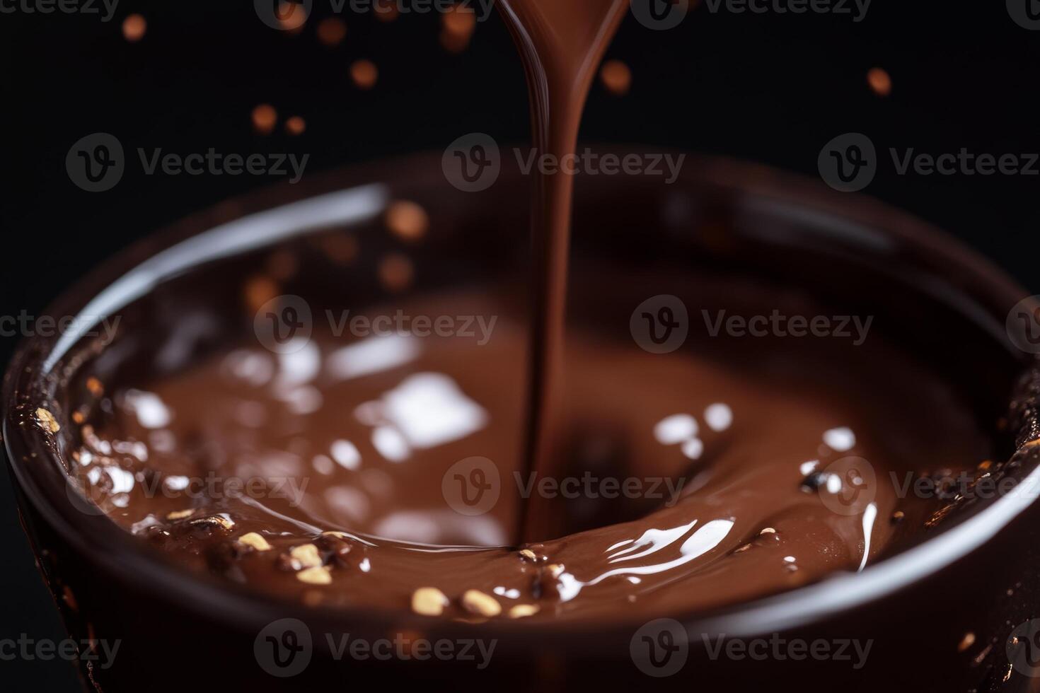 A warm drink of melted chocolate poured into a dark cup, set against a smooth black backdrop, evoking a cozy atmosphere photo