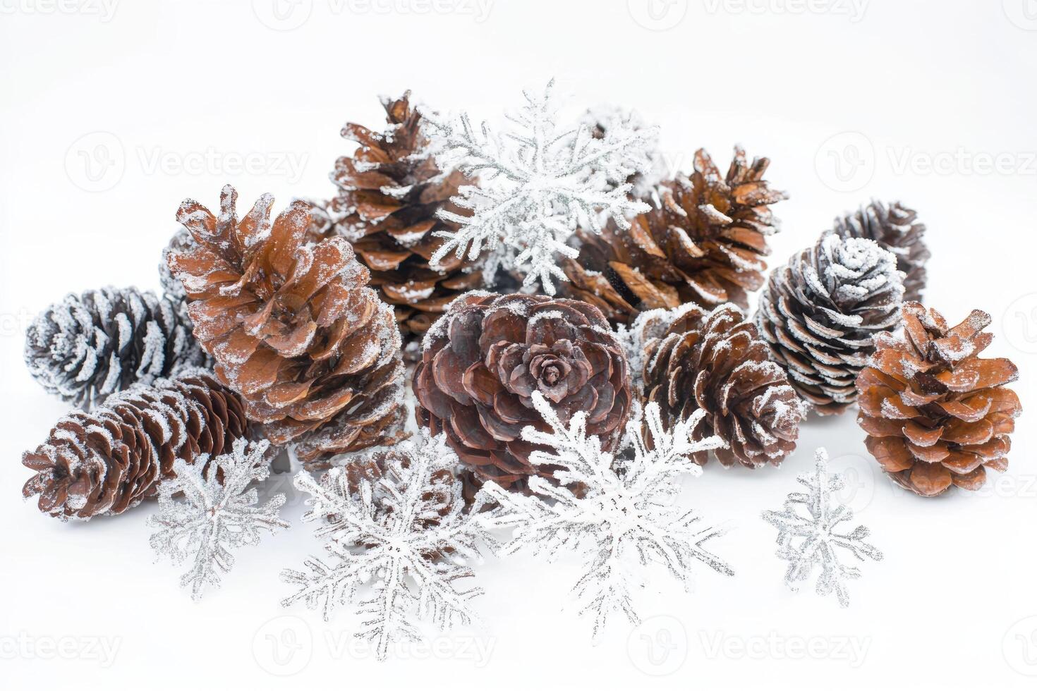 Snow-covered pinecones and delicate snowflakes arranged on a bright white background, capturing the essence of winter's beauty photo