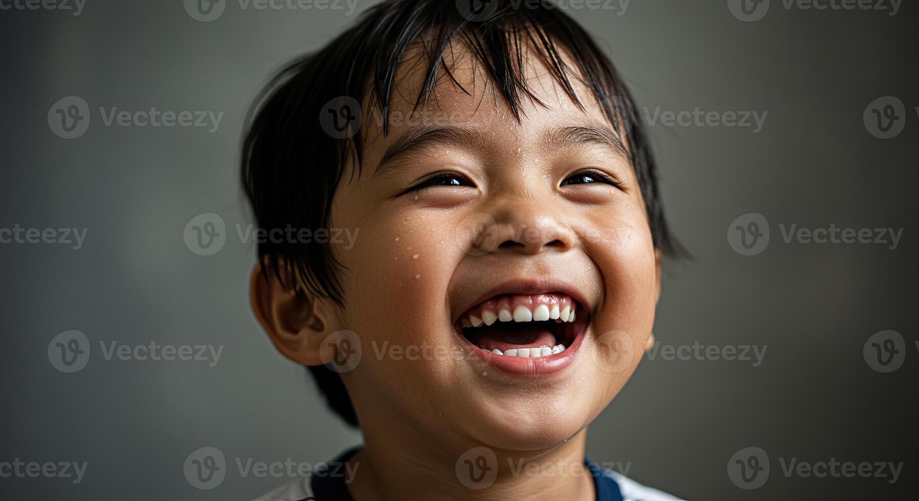 Adorable young Asian boy laughing joyfully with a happy expression photo