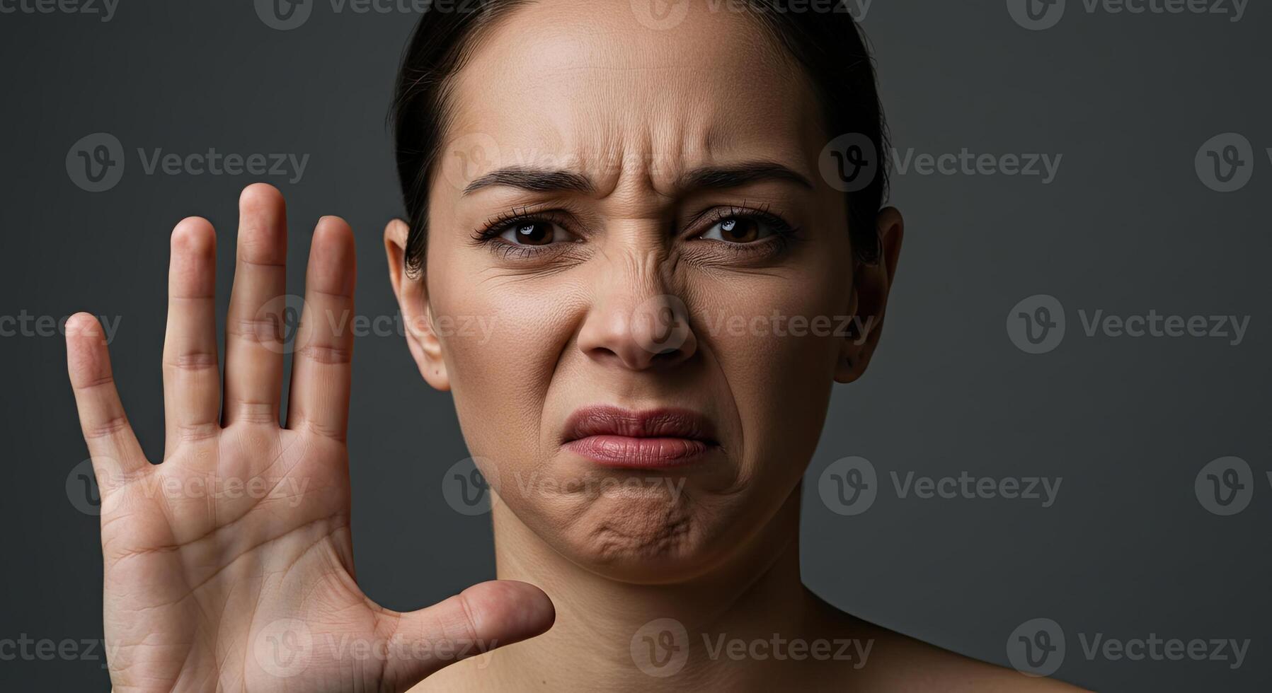 Disgusted young woman expresses aversion with hand gesture stop sign photo