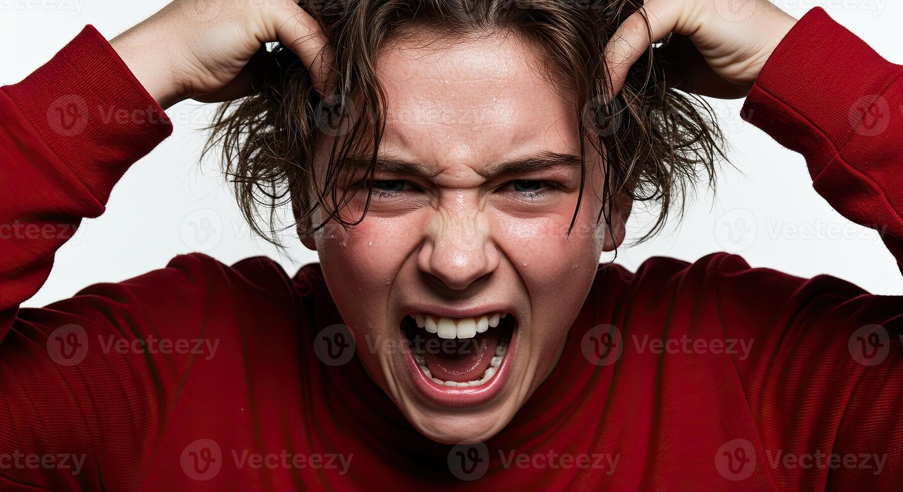 Frustrated young man screams pulling hair in a fit of rage indoors photo