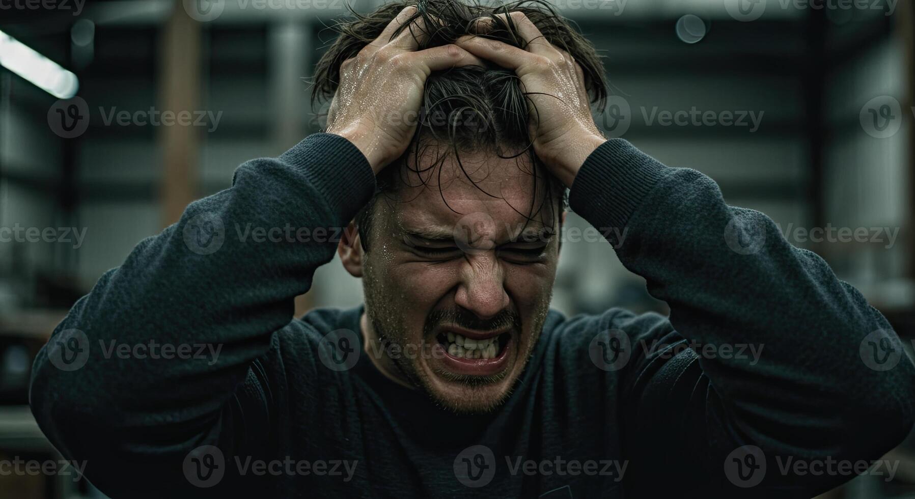 Frustrated man with sweaty hair pulls at his head in despair and stress photo