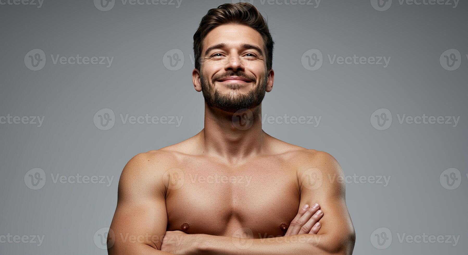 Handsome man with beard and muscular body smiles confidently posing shirtless photo
