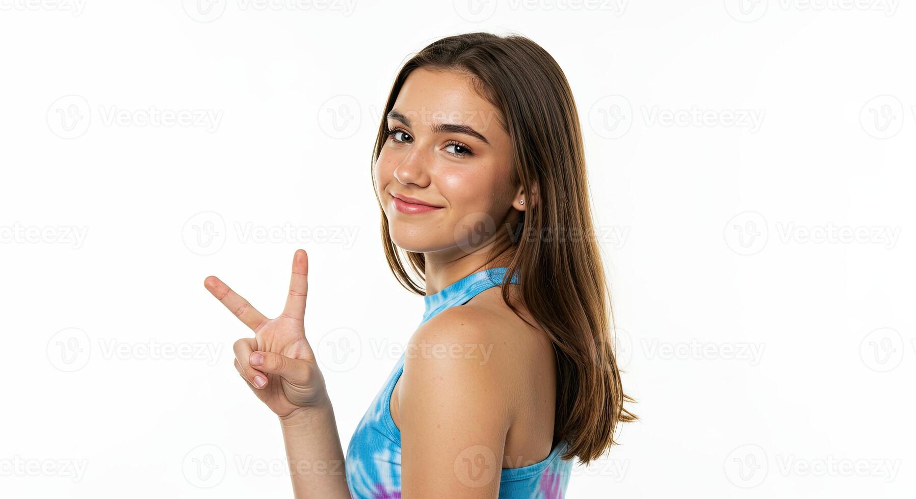Smiling teenage girl showing peace sign against white studio backdrop photo