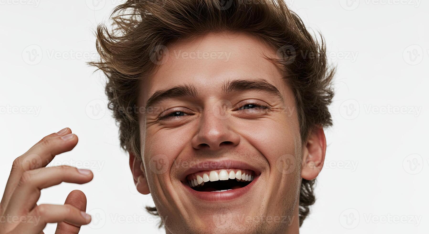 Smiling young man with brown hair expressing joy and positive emotion photo