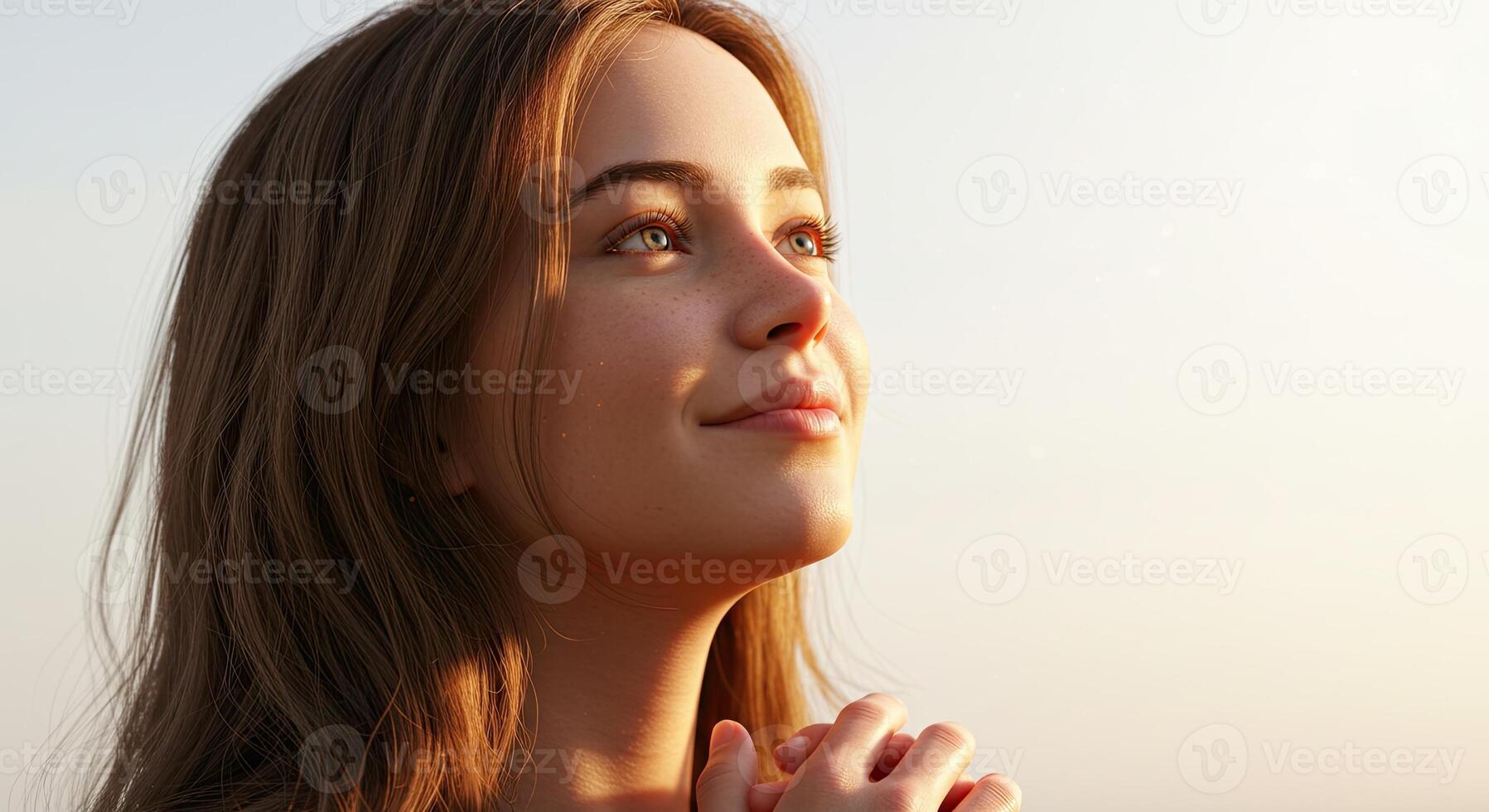 Young woman looking up in hope with peaceful expression and clasped hands photo