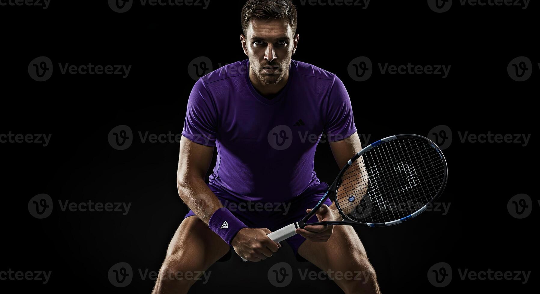 Focused tennis player in action pose with racket on a black background photo