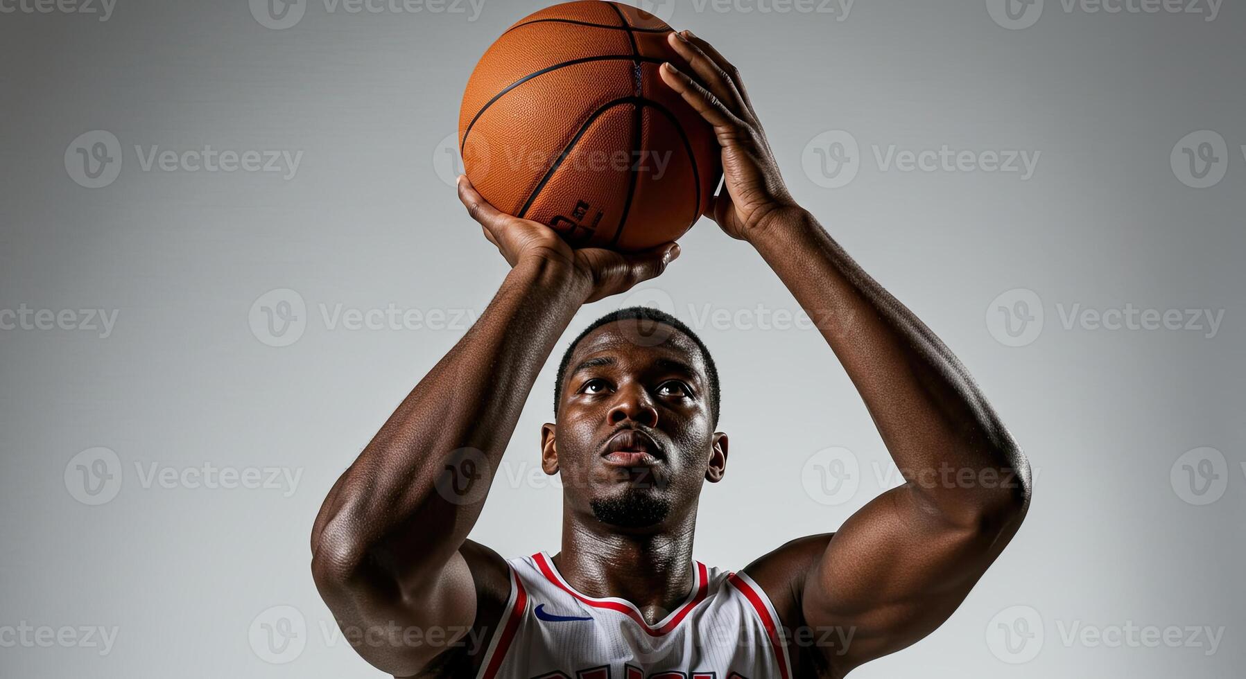 Focused young adult African American basketball player shooting ball photo
