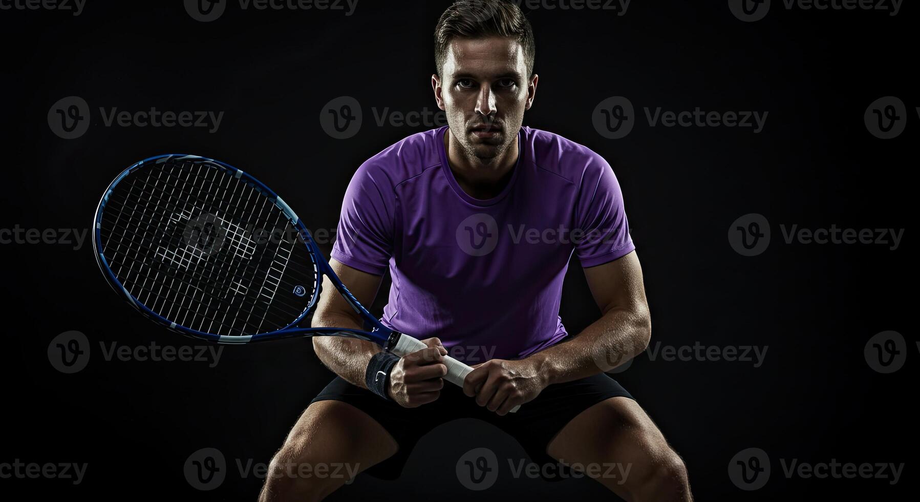 Intense male tennis player ready to serve holding racket on black background photo
