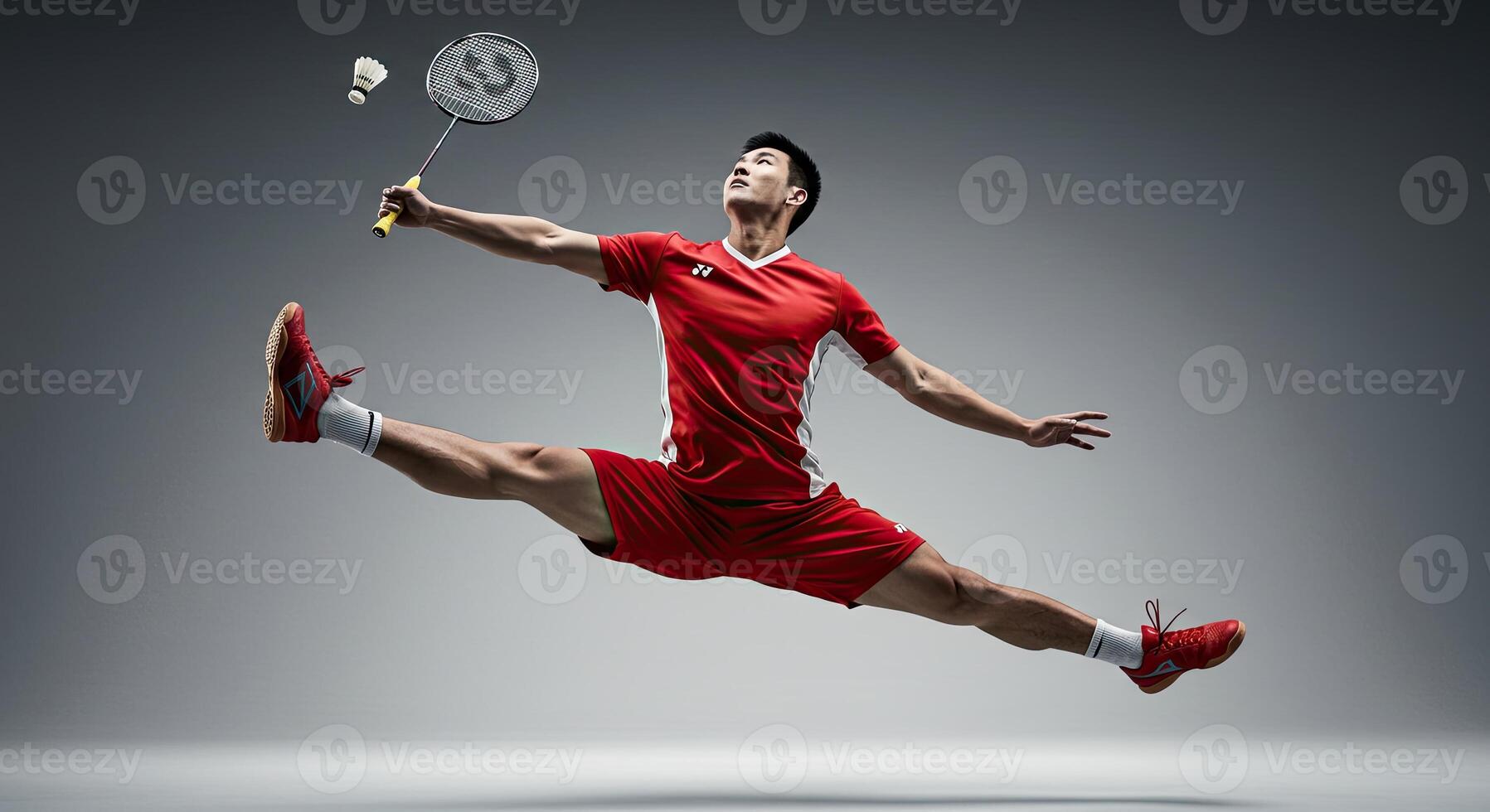 Male badminton player in mid air split shot with racket and shuttlecock photo