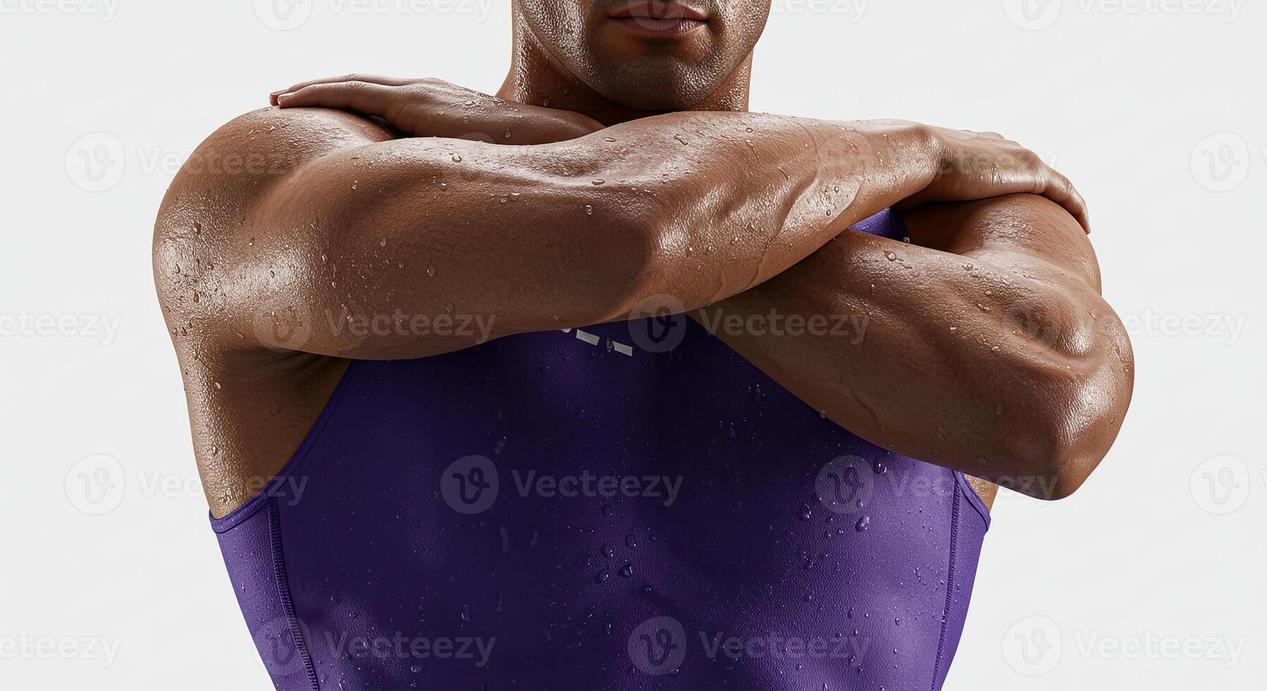 Muscular athletic man stretching arms in purple tank top after workout photo