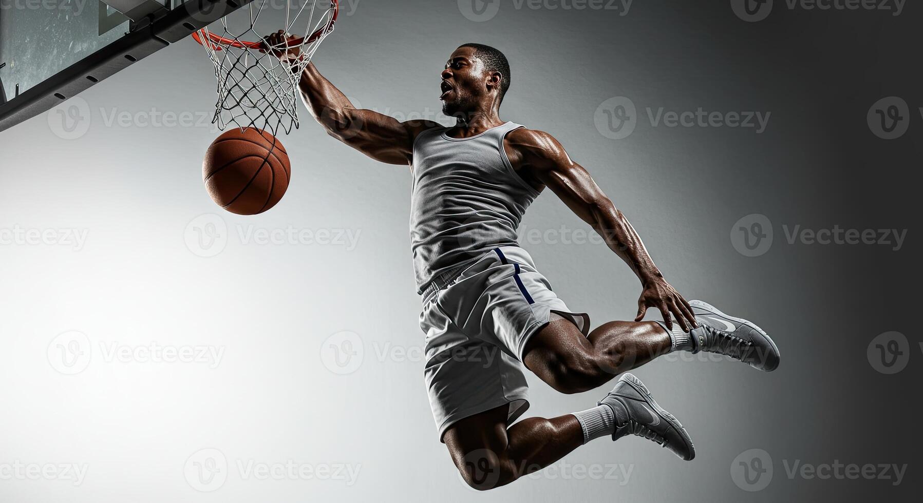Powerful African American basketball player dunking with intense focus photo