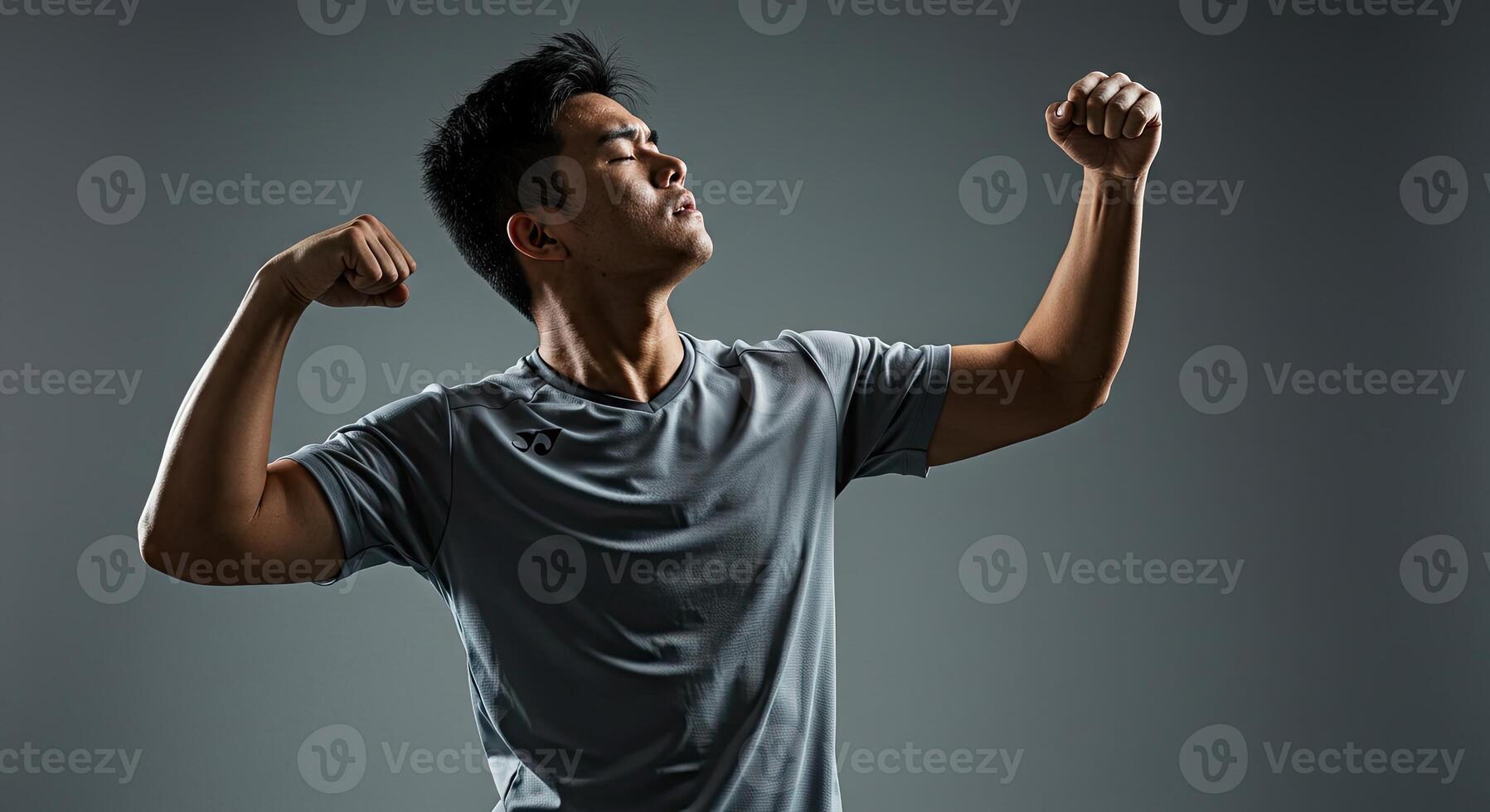 Strong Asian man flexing his muscles in a display of strength and power photo