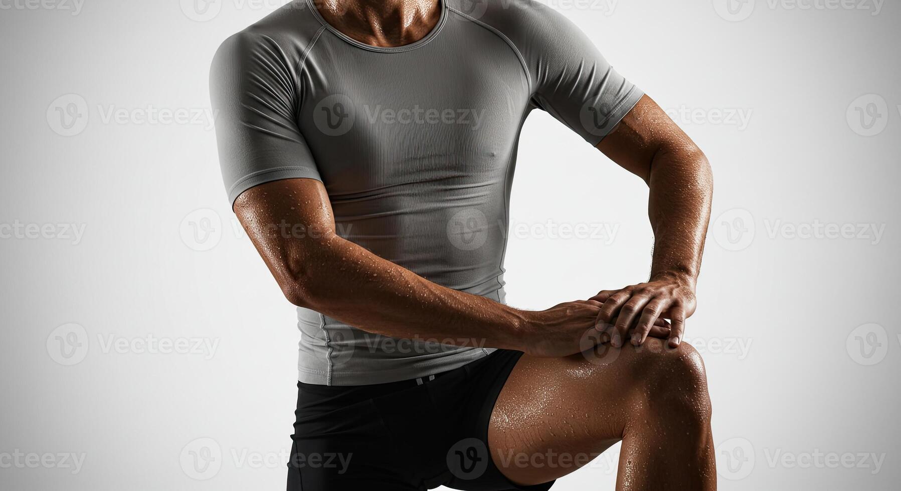 Sweaty athletic man in compression shirt flexing muscles after workout photo