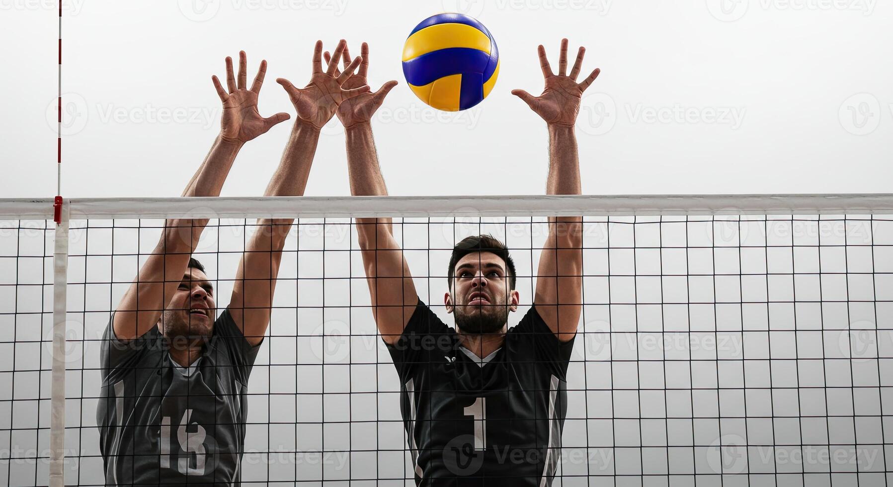 Volleyball players blocking a spike at the net during a competitive game. photo