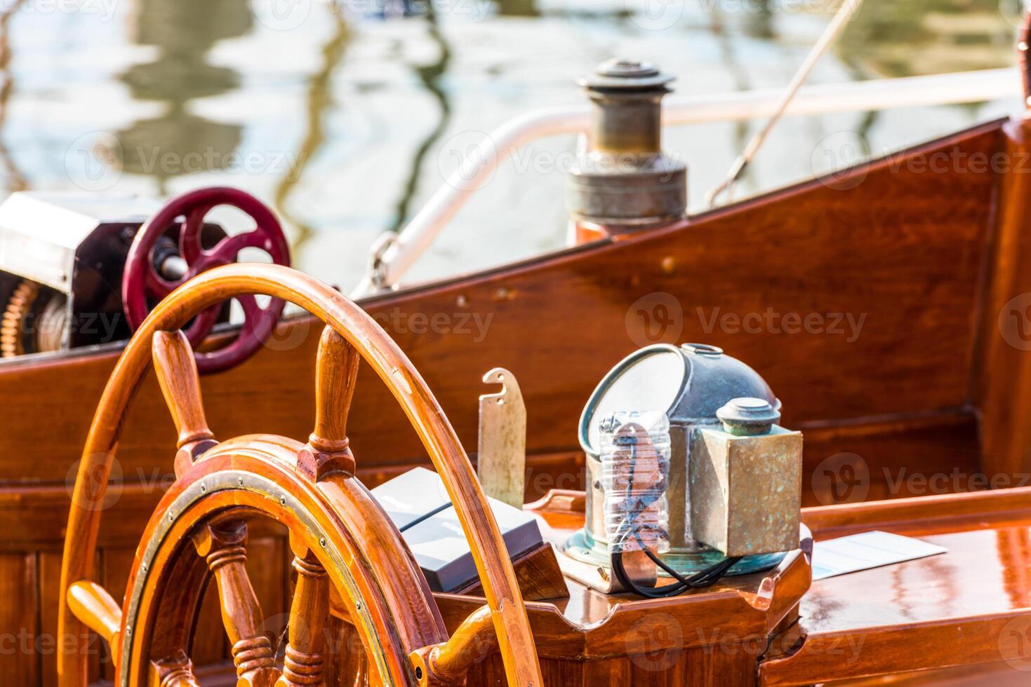 Sailboat helm with wooden wheel and nautical equipment in sunlight, background photo