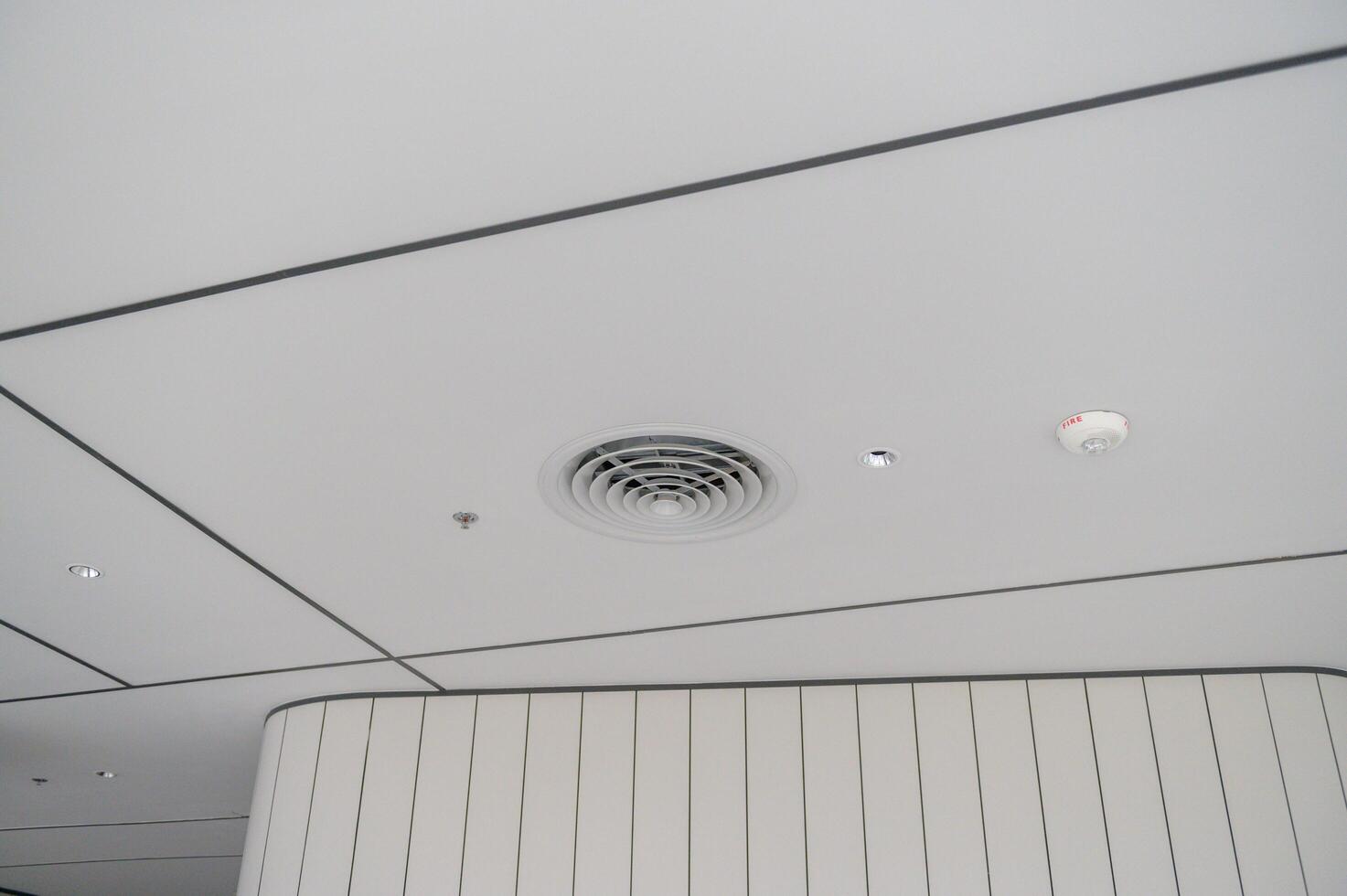 Clean modern office ceiling featuring air vents, recessed lighting, and grid pattern with smooth white panels creating sleek and professional atmosphere photo
