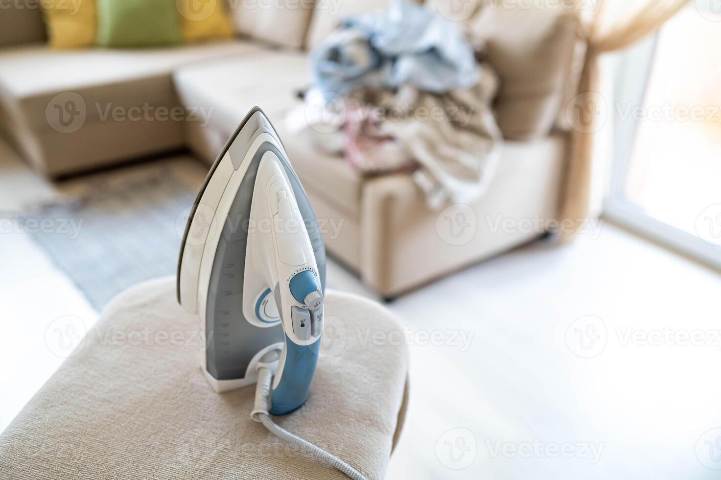 A blue and white iron sits on a couch photo