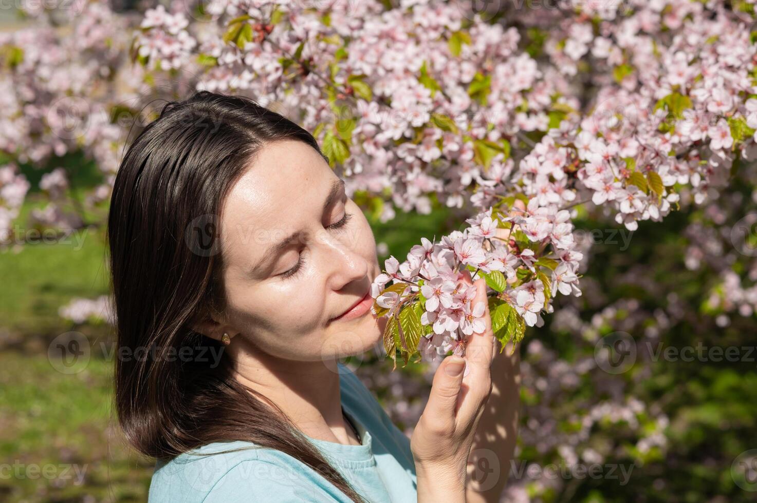 Smiling woman surrounded by blooming trees on a warm spring day photo