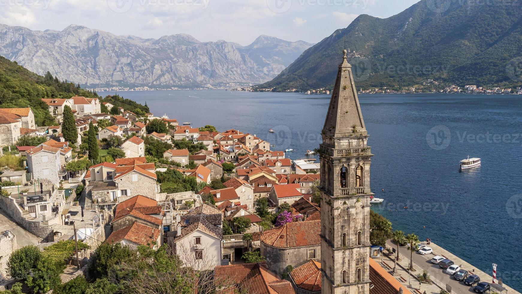 Aerial view of bell tower in the city of Perast on a sunny day. Old venetian tourist town located in the Adriatic Sea coast in the Bay of Kotor, Montenegro photo