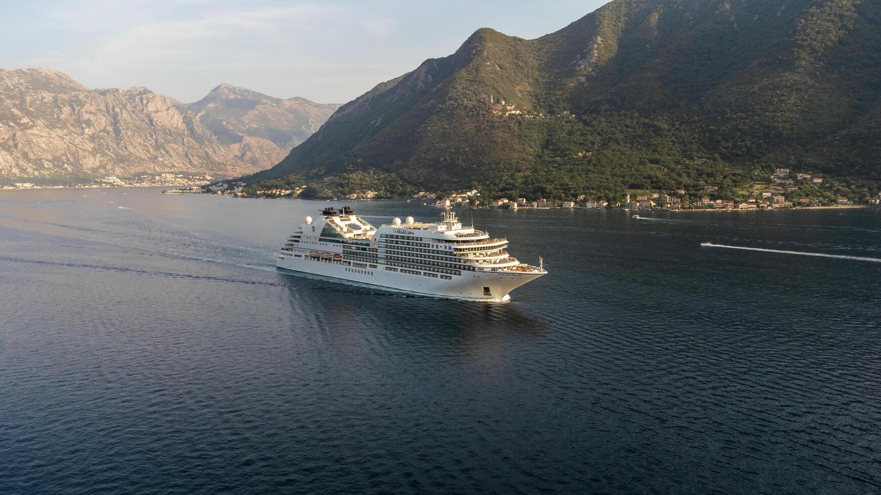 Bay of Kotor, Montenegro, 08-27-2024, Aerial view of a cruise ship at sunset sailing in the Bay of Kotor tourist destination in summer in Montenegro photo
