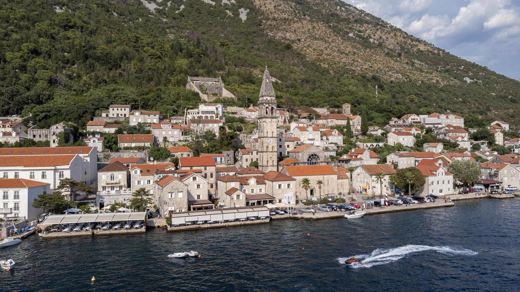 Aerial view of Perast city on a sunny day. Old venetian tourist town located in the Adriatic Sea coast in the Bay of Kotor, Montenegro photo
