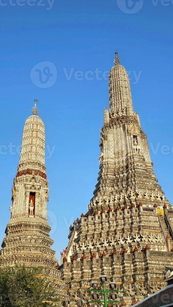 Wat Arun Temple Towers Against a Clear Blue Sky photo