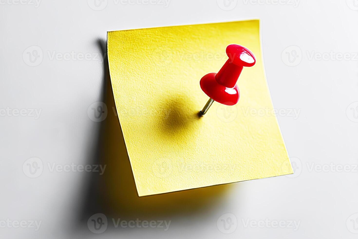 A red push pin on a yellow sticky note photo