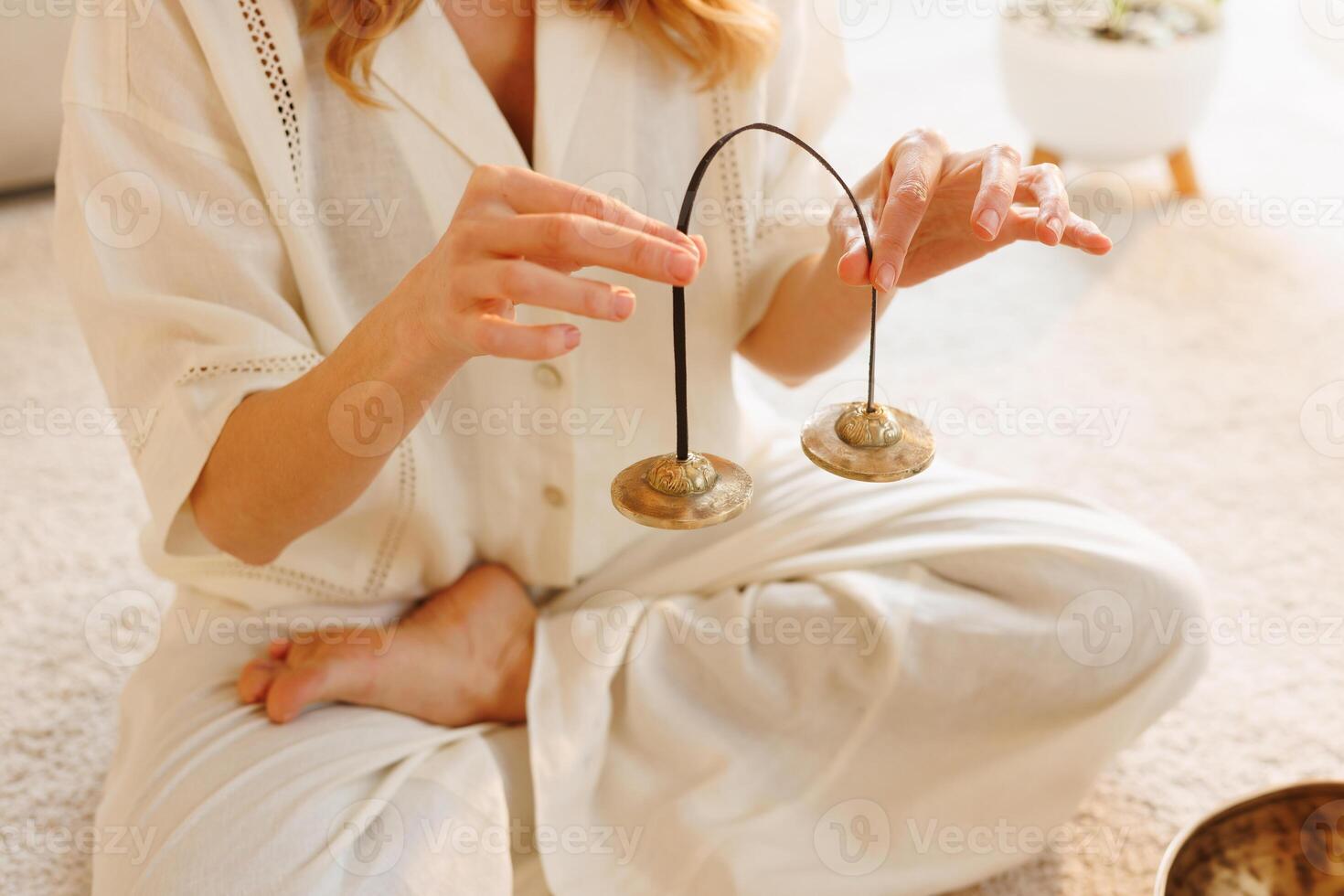 Close-up of woman meditating with Tibetan tingsha cymbals for spiritual clarity and energy balance. photo