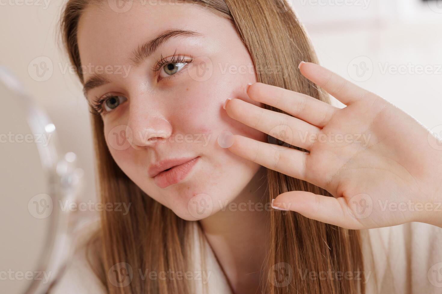 Young woman using acne patch on face, closeup skincare routine for blemish treatment. photo
