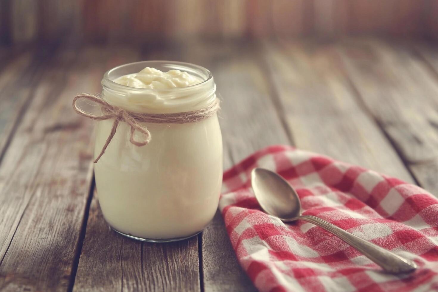 Yogurt in a jar on a wooden table photo