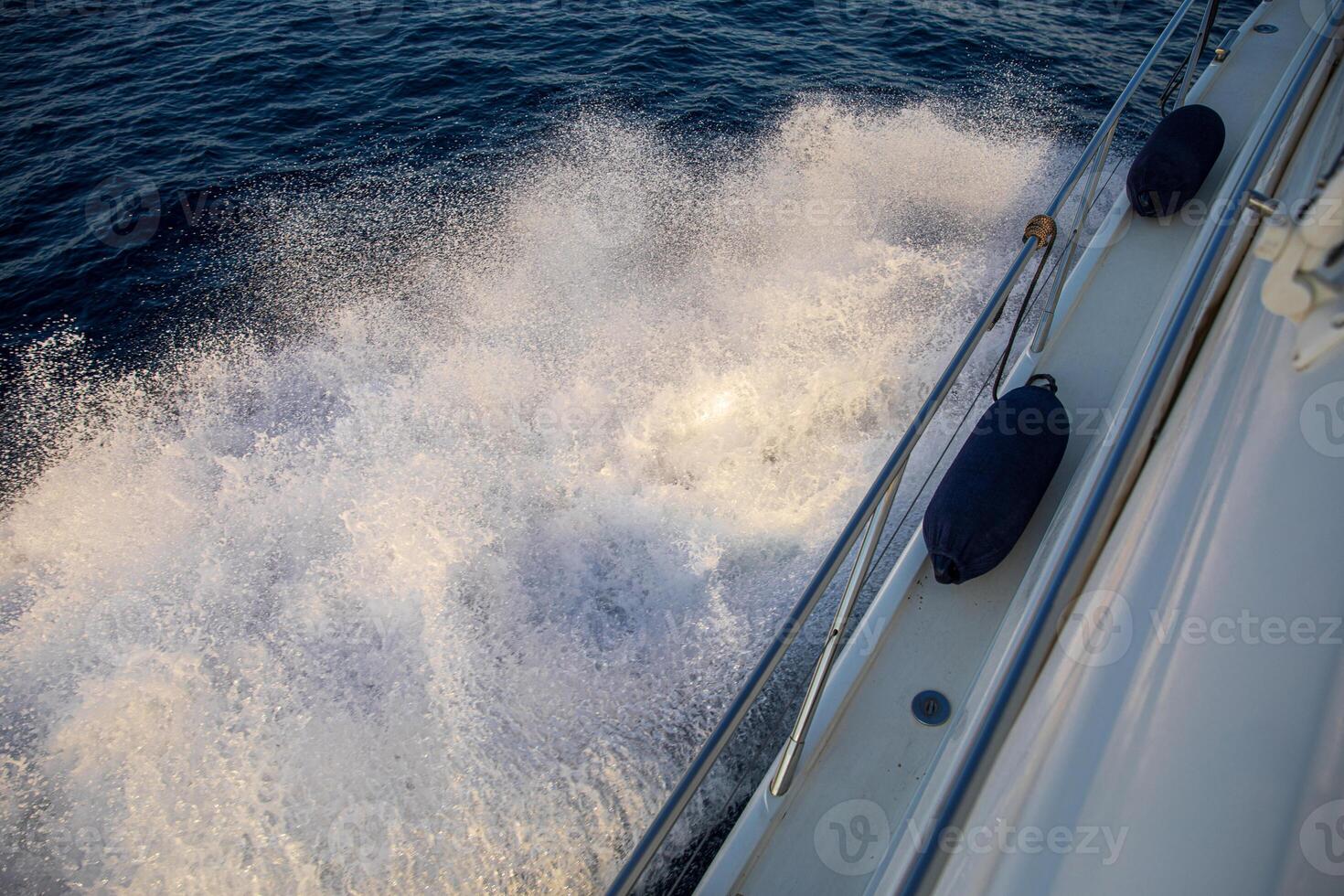 Vibrant sailboat moves gracefully across the blue waters of Greece, creating splashes as it glides through the waves during a sunny day of exploration. photo