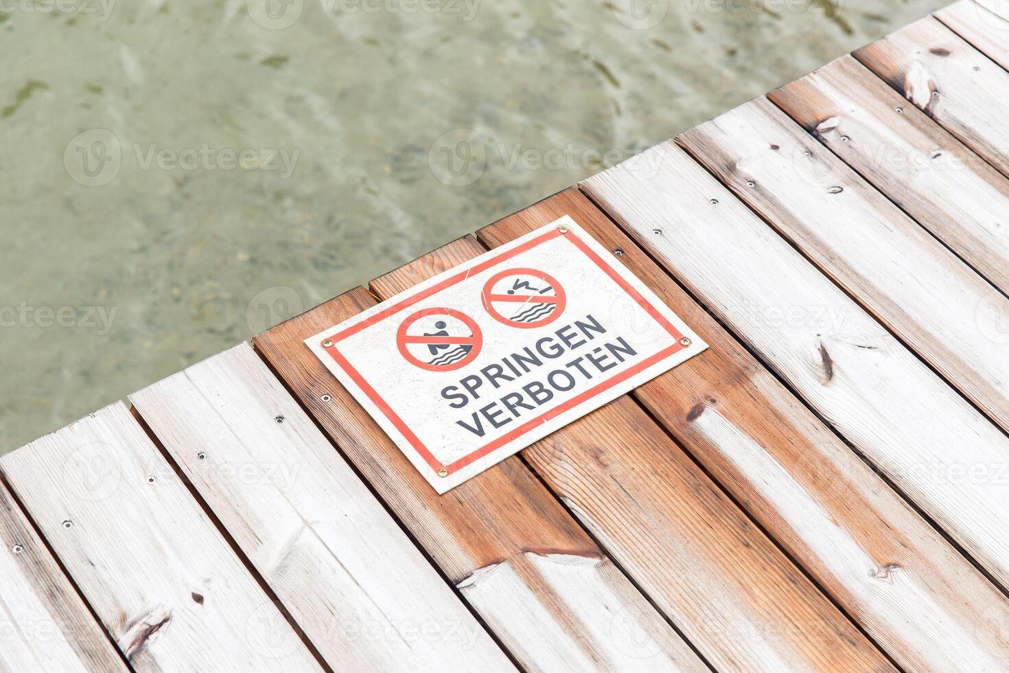 Wooden dock with no diving and swimming signs in german photo