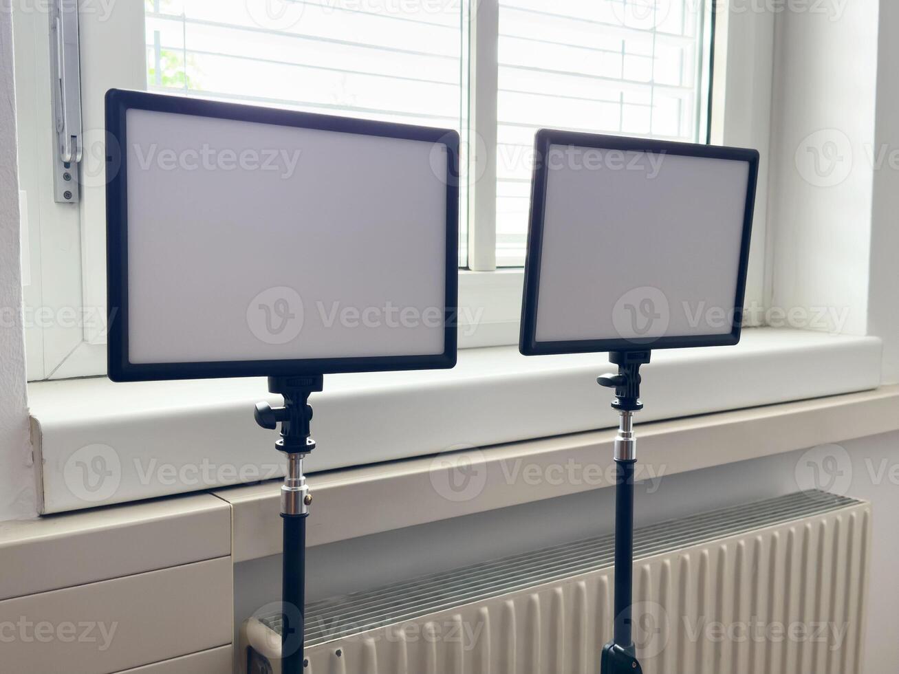 Pair of professional studio led panel lights on adjustable stands near window photo