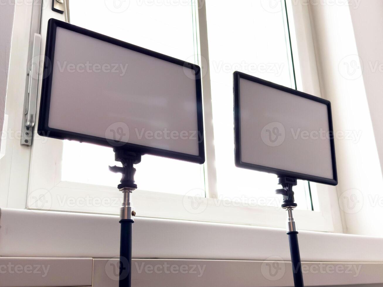 Dual rectangular led panel lights in front of a bright window photo