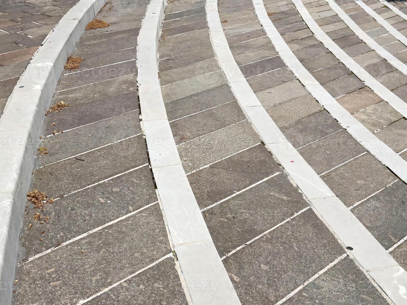 Curved stone pavement with white stripes in urban setting photo