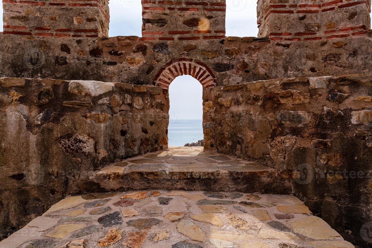 Ancient Stone Fortress Gateway Overlooking a Tranquil Ocean Horizon photo