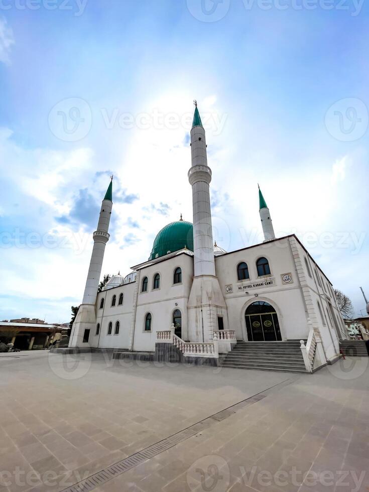 A beautiful mosque with a green dome and four tall minarets under a serene sky, showcasing Islamic architecture and spirituality. photo