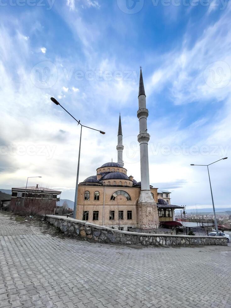 A beautiful mosque with a dome and two tall minarets under a cloudy sky, showcasing Islamic architecture and spirituality. photo