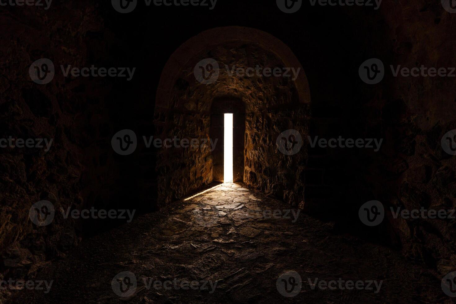 Mystical Stone Corridor Illuminated by Light Through an Open Doorway photo