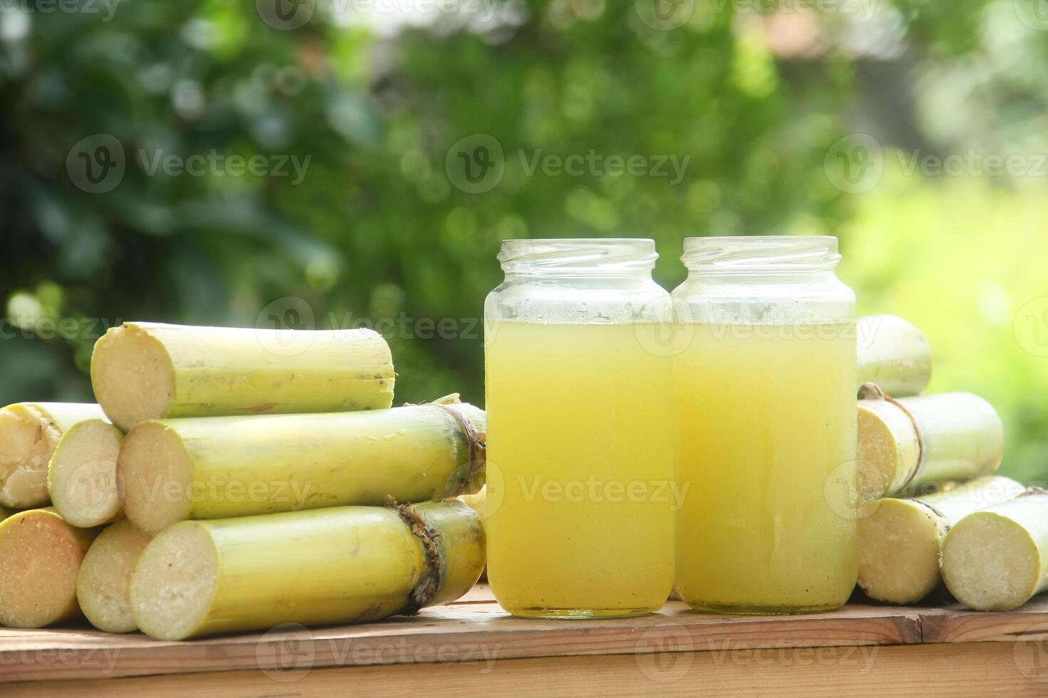 Two jars of lemonade sitting on top of some sticks photo