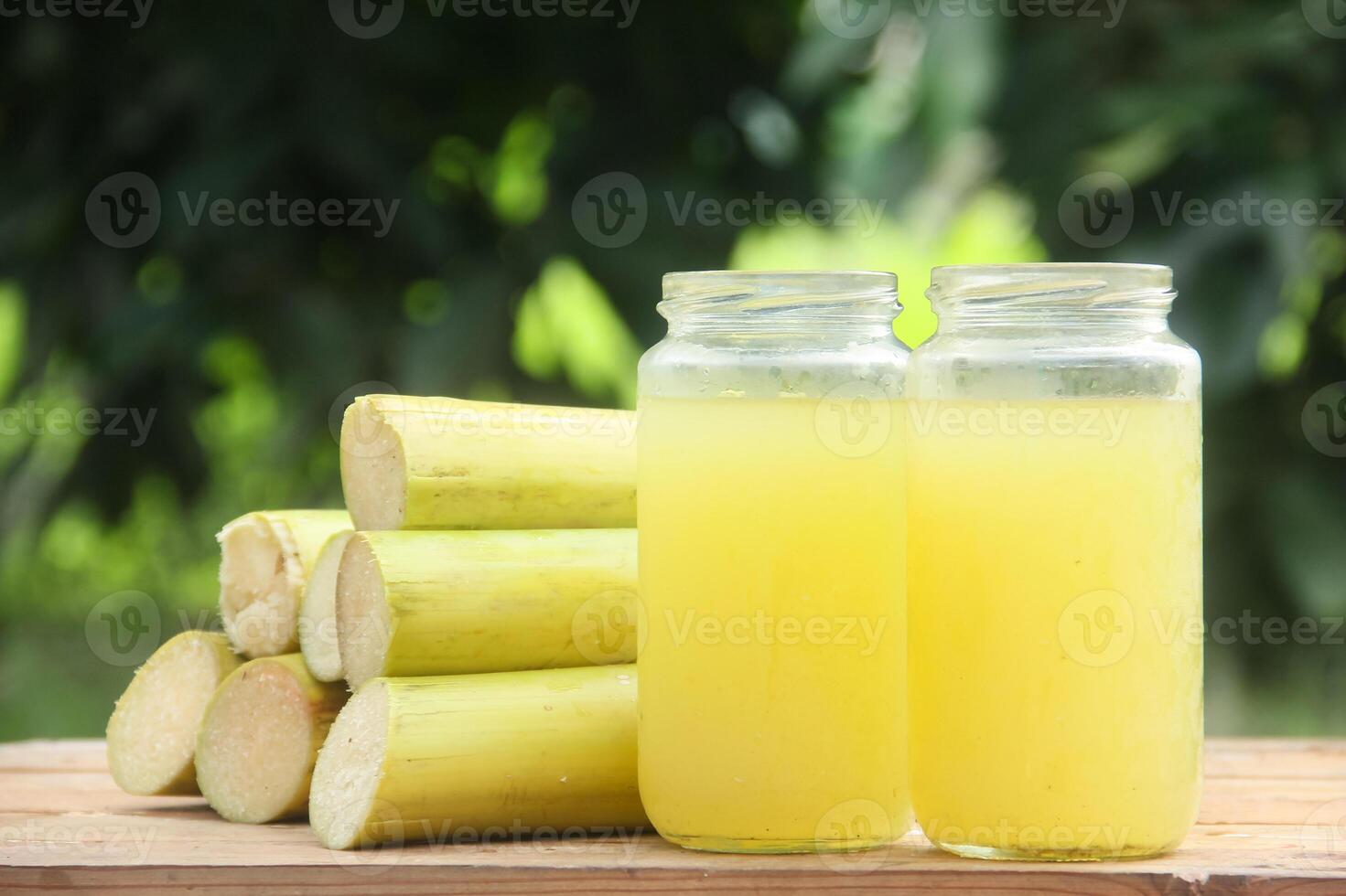 Two jars of sugarcane juice on a wooden table photo