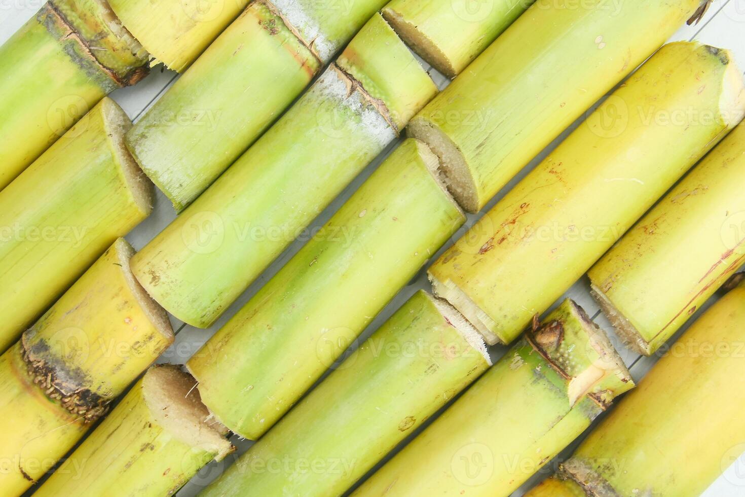 The shape of fresh yellow sugar cane stalks or Saccharum officinarum arranged on a table photo