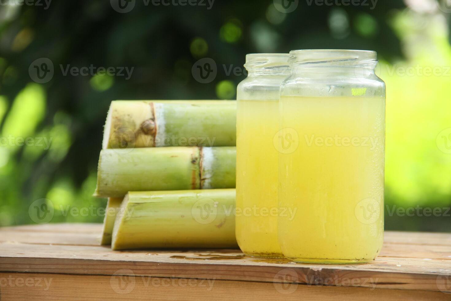 Two jars of lemonade with some sugar cane photo