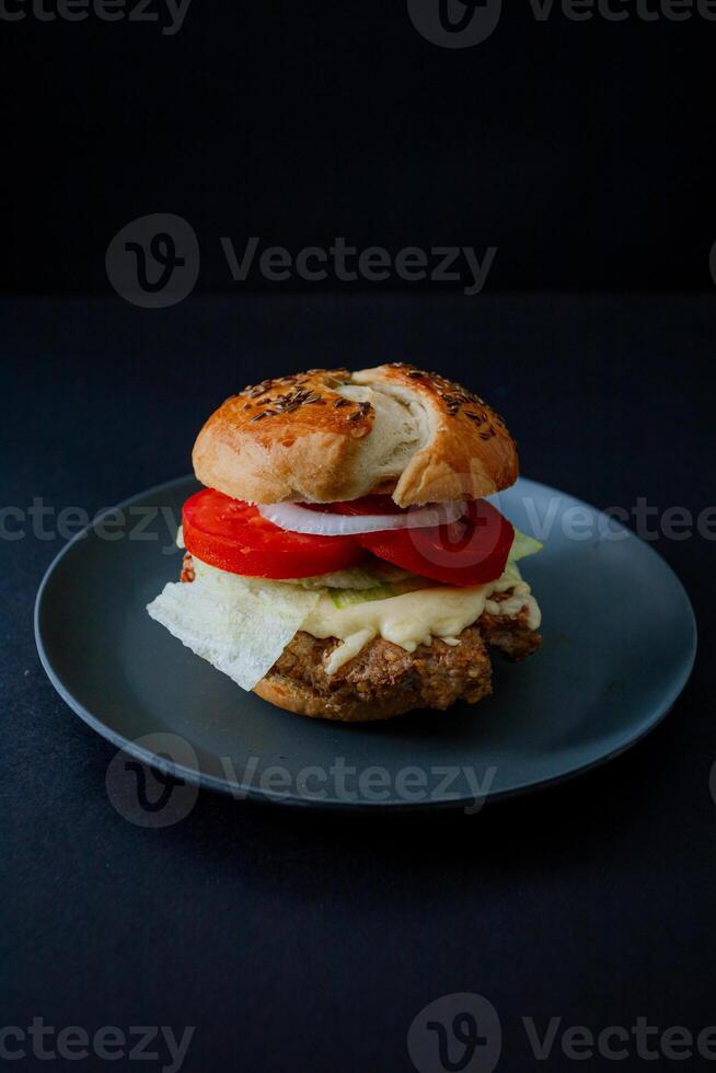 a hamburguer on a plate with lettuce and tomato photo