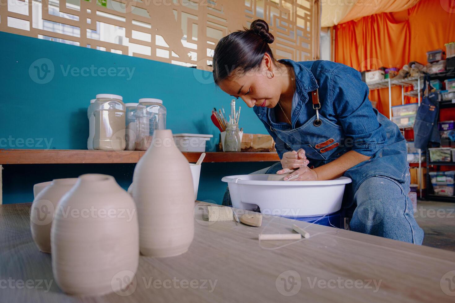 a latin woman is making a pottery vase photo