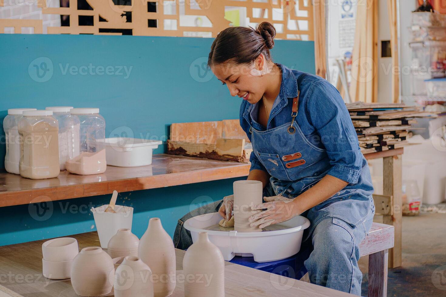 a woman is making a pottery vase photo